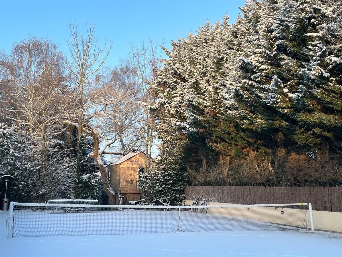 Court de tennis et cabane perchée sous la neige aux Cabanes d’Alex, en hiver