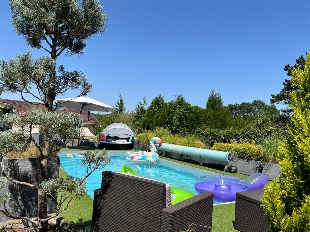 Piscine extérieure à l'eau salée, entourée de verdure — Les Cabanes d'Alex
